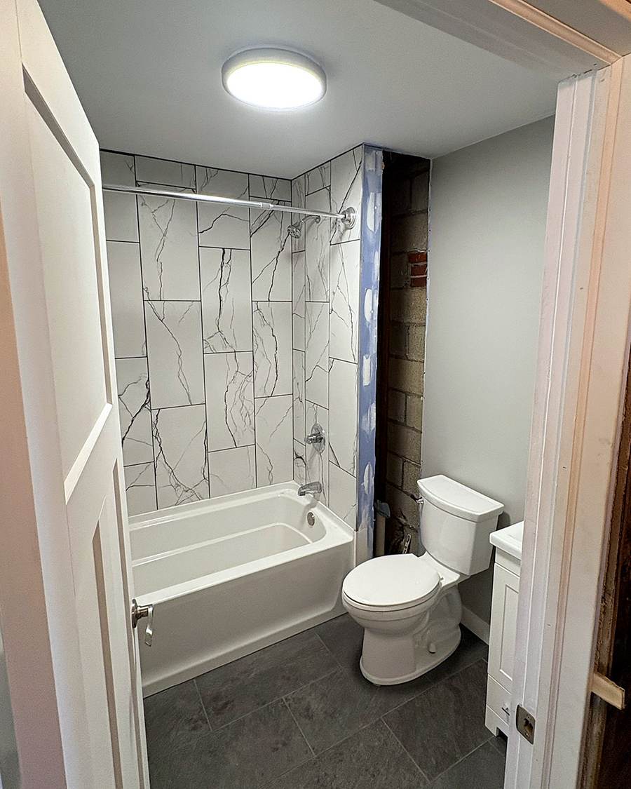 White alcove bathtub set in open framing during a Leesburg bathroom remodel