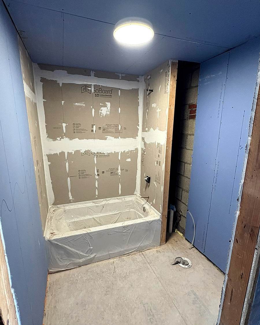 Cement board on the tub surround, before tile, in a Leesburg apartment bathroom