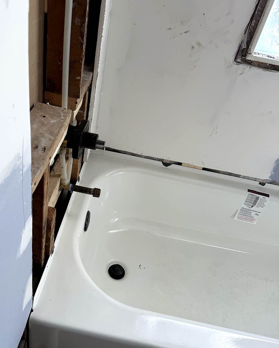 White bathtub set in open framing during a South Bend bathroom remodel