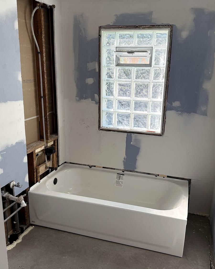 New white bathtub under a glass-block window during a South Bend bathroom remodel